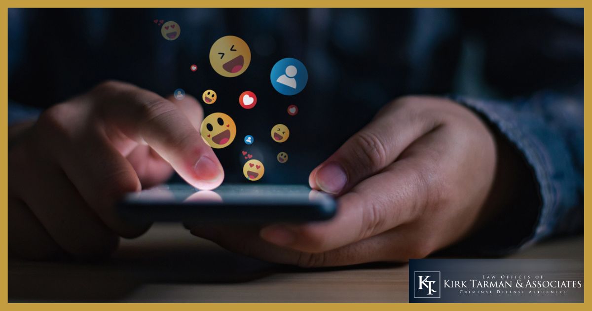 Man on social media with emojis coming out of the cell phone